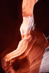 Nature red sandstone textured background. Swirls of old red  sandstone wall abstract pattern and sun beam in the amazing Upper Antelope Canyon, Page, Arizona, USA.