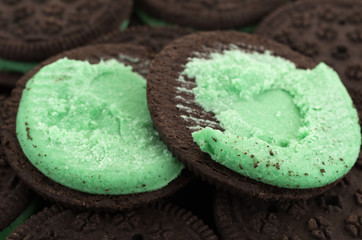 Close view of an opened mint creme sandwich cookie on top of other cookies.