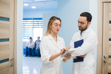 Medical Staff Having Discussion In Modern Hospital Corridor