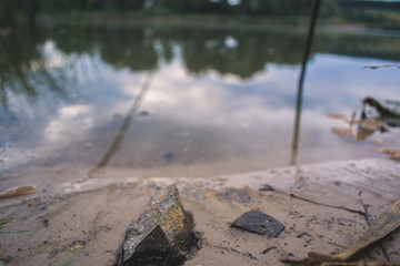 Stone on the sandy shore of the pond.