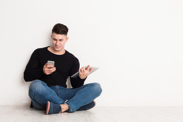 Male student study online, sit with laptop and using mobile phone