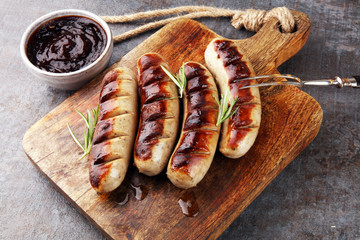 Fototapeta Grilled sausages with sauce ketchup on a wooden table - Home-made Pork Sausages obraz