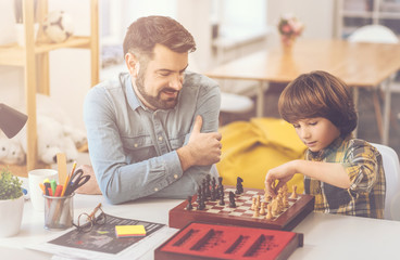 Positive nice father and son playing chess