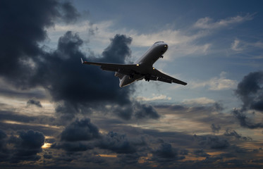 Fototapeta na wymiar Airplane flying in sky with storm clouds