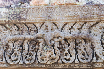 Carving with religious scenes include the god Indra atop his three-headed elephant Airavata. Walls of the East Mebon temple in Angkor Complex, Siem Reap, Cambodia.
