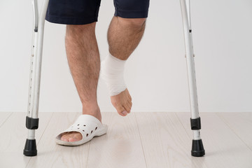 足を怪我した男、松葉杖