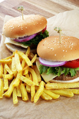 fresh tasty burger and french fries on wooden table