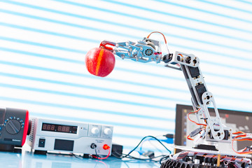 robot holds an apple  in his arm