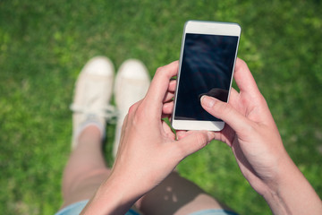 Close up pf female using blank screen smartphone in nature