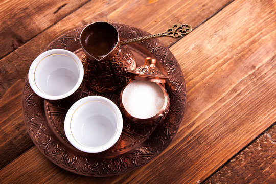 Antique bronze pitcher and coffee cup set with dates in a tray isolated on a white background,Turkish coffee set on wooden background.