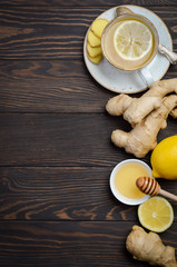 Ginger root tea with lemon and honey on wooden background, top view, copy space
