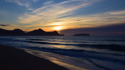 Sunrise over the headland and Atlantic Ocean from the beach at Porto Santo Island, 43 kilometres north of Madeira, Portugal