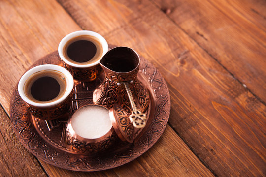 Antique bronze pitcher and coffee cup set with dates in a tray isolated on a white background,Turkish coffee set on wooden background.