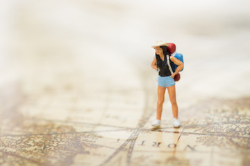 Miniature person: Backpacker travel to destinations on the map. Using as travel business concept