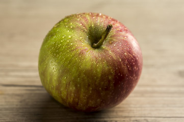 Close up shot of a red apple on wooden table