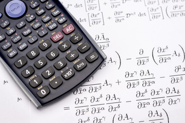 Close up shot of scientific calculator and mathematical equations sheets