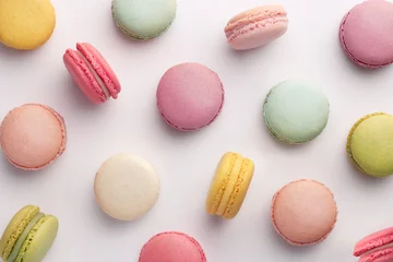 Fotobehang Macarons Macaronspatroon op witte achtergrond. Kleurrijke Franse desserts. Bovenaanzicht