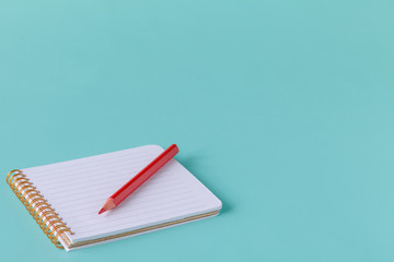 open spiral blank notebook with pencil on blue paper background