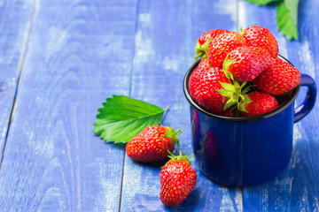 Raw strawberry on wooden table in garden.  Summer background.