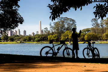 Cyclist by the lake in Ibirapuera Park, Sao Paulo, Brazil, taking photos.