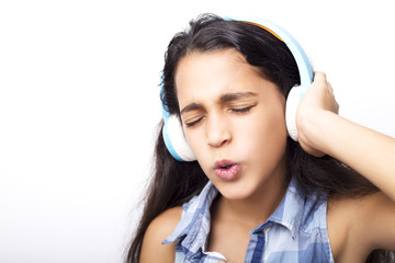 Afro-American little girl with headphones listening to music on white background