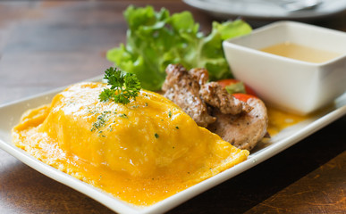 omelete rice with roasted pork on wood table