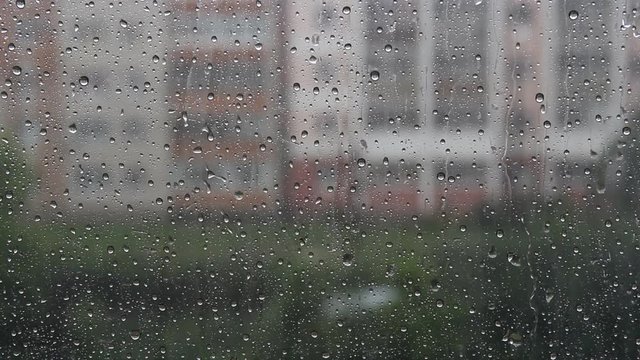 Drops of rain flow down the glass. Raining outside the window.