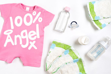 Babies goods diaper, baby powder, cream, shampoo, oil on white background with copy space. Top view or flat lay.