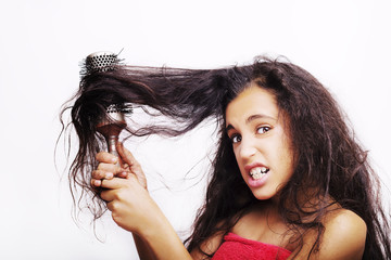 Hair care concept with portrait of girl brushing her unruly, tangled long hair isolated on white