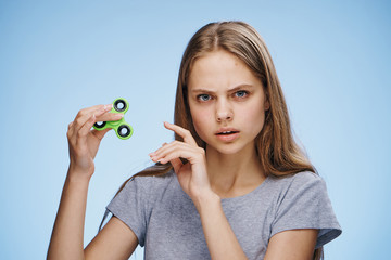 Young beautiful woman on a blue background holds a spinner