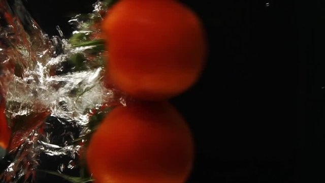 Ripe tasty red tomatoes dropped into the water