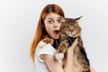 Young beautiful woman on white isolated background holds a cat