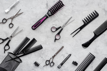 Pattern of combs and hairdresser tools on grey table background top view