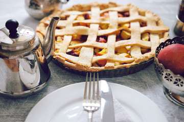 Tasty summer fruit pie with peach filling, tea and cookies