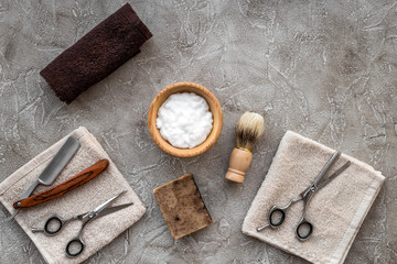 Fototapeta na wymiar Preparing for men shaving. Shaving brush, razor, foam, sciccors on grey stone table background top view copyspace