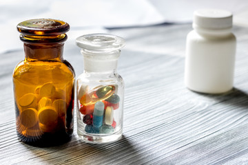 Vitamins and supplements. Pills and pill bottle on grey wooden table background copyspace