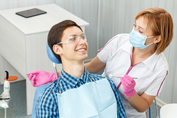 Female dentist and young man in dentist office