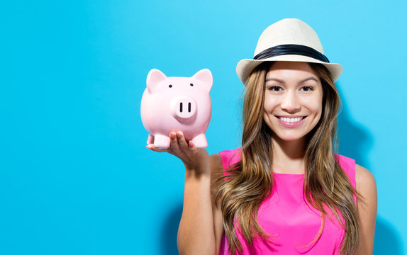 Young woman with a piggy bank on a blue background