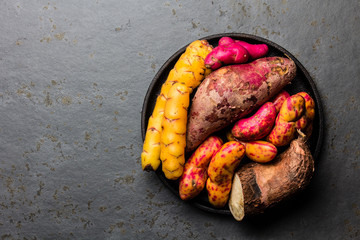 Peruvian raw ingredients for cooking - yuca, colored sweet potatoes and camote batata. Top view