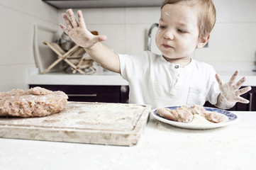 Baby boy kneading meatballs