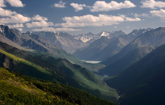 Mountain valley with a river and lake on the background of glaciers and snow peaks with high, steep slopes  view from above Kucherla Altai Mountains Siberia, Russia