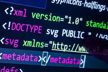 Fototapeta premium Computer with programming code and finger touching the screen