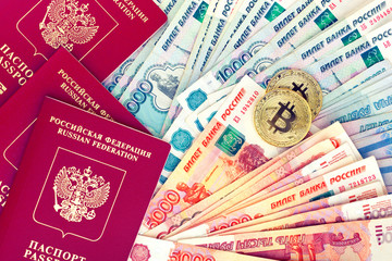 Bitcoin coins and passports RF on background of russian banknotes