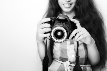 Cute brunette little girl holding an photo camera, isolated on white background