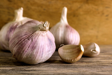 Garlic clove and garlic bulb on wooden background