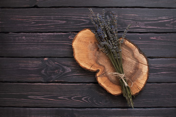 A bouquet of lavender on a dark wooden background is a top view.