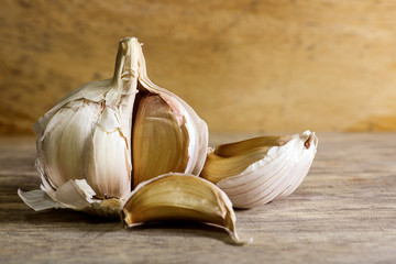 Garlic clove and garlic bulb on wooden background