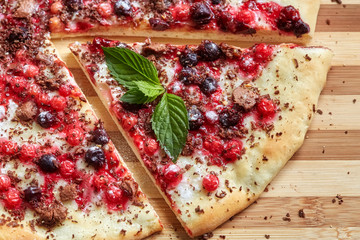 Piece of sweet pizza with currant, redcurrant, mint and chocolate