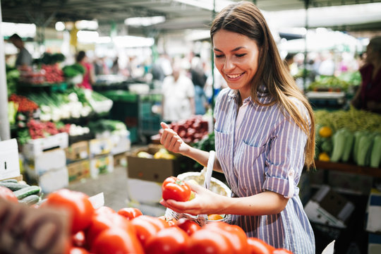 Picture of woman at marketplace buying vegetables
