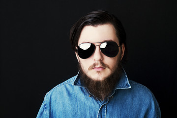 Studio portrait of caucasian young man standing up on black background
